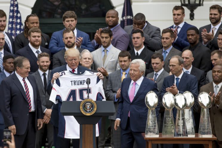 President Donald Trump is presented with a New England Patriots jersey by Patriots head coach Bill Belichick, left, and New England Patriots owner Robert Kraft, center, during a ceremony on the South Lawn of the White House in Washington, Wednesday, April 19, 2017, where the president honored the Super Bowl Champion New England Patriots for their Super Bowl LI victory. Also pictured is New England Patriots president Jonathan Kraft, second from right. (AP Photo/Andrew Harnik)