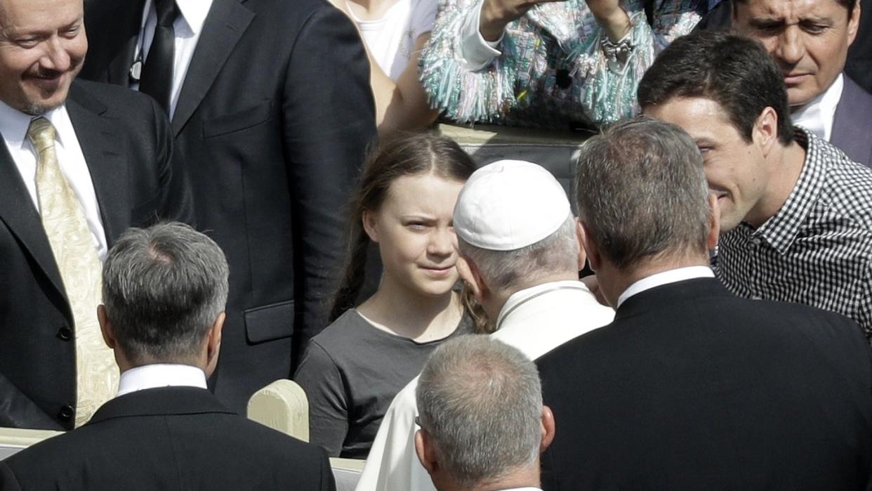 Papst Franziskus begrüßt die schwedische Klimaaktivistin Greta Thunberg (M) während seiner wöchentlichen Generalaudienz auf dem Petersplatz im Vatikan. Foto: Gregorio Borgia/AP