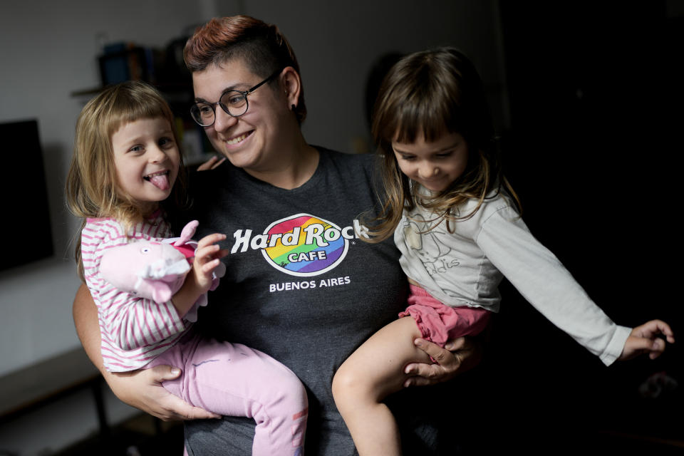 Anastasia Domini holds her 3-year-old twin daughters Una, left, and Agata, at their home which she shares with her wife Anna, in Buenos Aires, Argentina, Tuesday, April 18, 2023. The couple are part of an increasing number of Russians from the LGBTQ+ community who decided to leave their homeland to escape both discrimination and the war with Ukraine and are choosing to settle in Argentina. (AP Photo/Natacha Pisarenko)