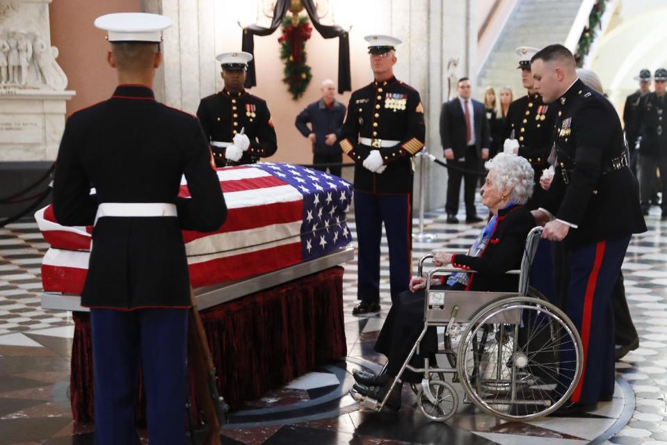 Annie Glenn, is taken to the side of her husband John Glenn's casket as he lies in honor, Friday, Dec. 16, 2016, in Columbus, Ohio. Glenn's home state and the nation began saying goodbye to the famed astronaut who died last week at the age of 95. (AP Photo/John Minchillo)