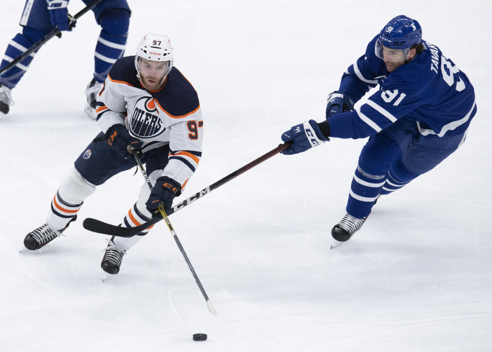 Toronto Maple Leafs center John Tavares (91) chases down Edmonton Oilers center Connor McDavid (97) during the first period of an NHL hockey game Friday, Jan. 22, 2021, in Toronto. (Frank Gunn/The Canadian Press via AP)