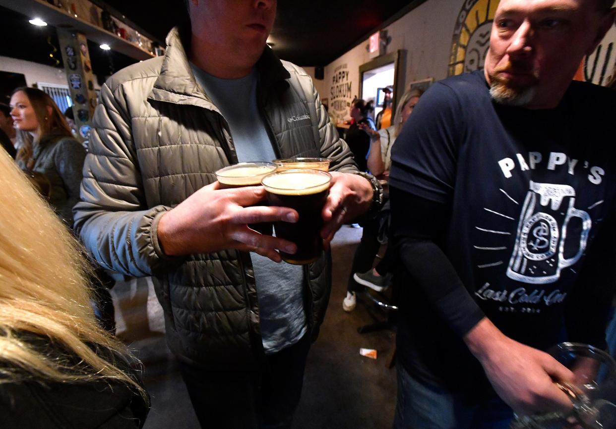 A customer squeezes through the crowd after waiting in a line for beer at Pappy Slokum Brewing Company. The line Saturday stretched out the door. It was the pioneering Abilene brew pub's last day of business and customers flocked there to enjoy their final pints.