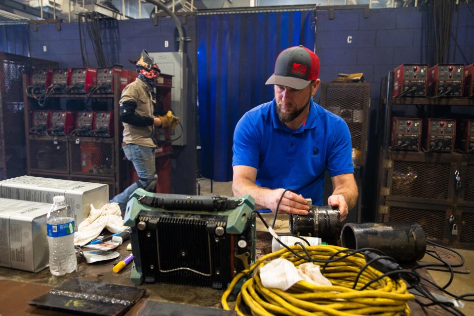 Nathan Weston, a worker at the industrial company Acuren, uses ultrasonic shear wave testing to inspect a metal tube at the Día de los Muertos Welding Competition at Del Mar College on Friday, Nov. 4, 2022, in Corpus Christi, Texas.