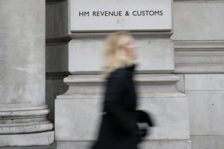 FILE PHOTO - A pedestrian walks past the headquarters of Her Majesty's Revenue and Customs (HMRC) in central London February 13, 2015. British lawmakers plan to call up the bosses of HSBC and the tax authority, HMRC, to quiz them over allegations some clients of HSBC's Swiss private bank evaded tax.     REUTERS/Stefan Wermuth