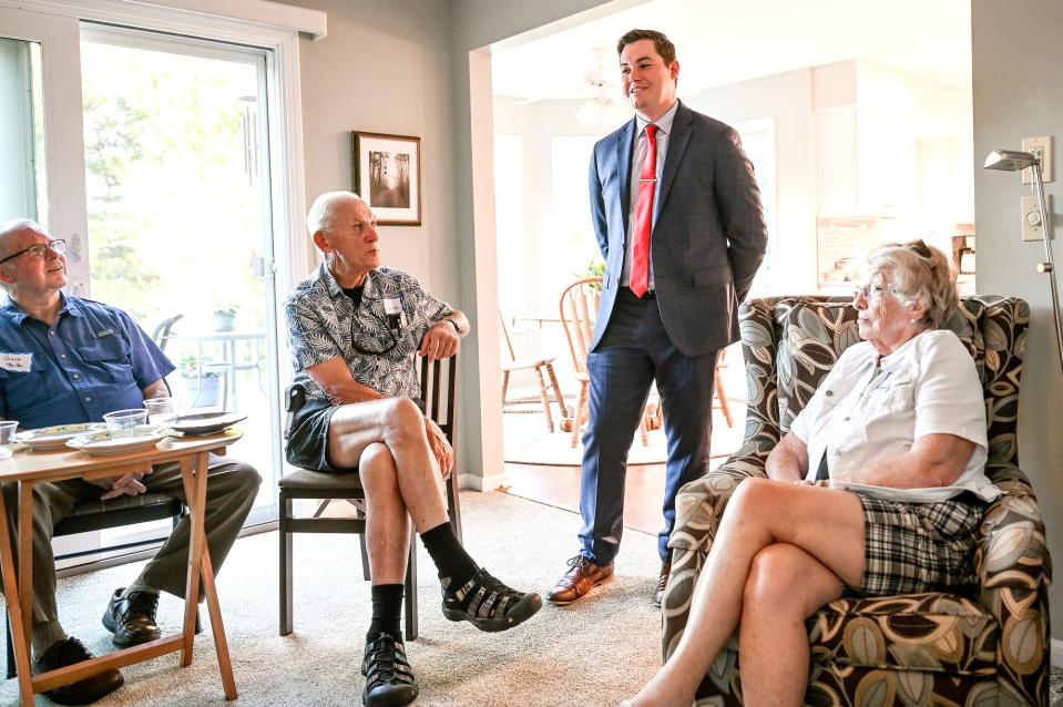 Logan Byrne, a state representative candidate, center, talks to people during a political fundraiser on Thursday, June 23, 2022, at a home in DeWitt.