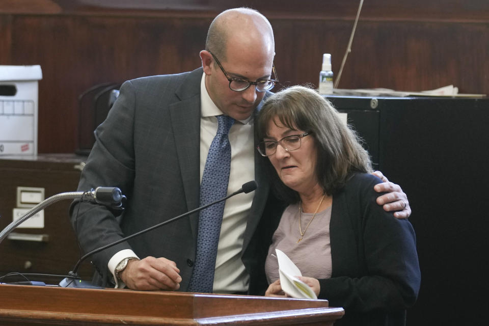 Prosecutor Jared Rosenblatt comforts Darlene Altman, daughter of Diane Cusick, as she reads a statement at a courtroom in Mineola, N.Y., Monday, Dec. 5, 2022. Richard Cottingham, the serial murderer known as the "Torso Killer", admitted Monday to killing a Cusick, a 23-year-old woman, outside a Long Island shopping mall in 1968 and four other women decades ago. (AP Photo/Seth Wenig)