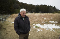 Naoto Matsumura speaks during an interview with The Associated Press at his farm land in Tomioka town, Fukushima prefecture, northeastern Japan, Friday, Feb. 26, 2021. About 10 kilometers (6 miles) south of the wrecked Fukushima Dai-ichi nuclear power plant, rice farmer Matsumura defied a government evacuation order and stayed on his farm to protect his land the cattle abandoned by neighbors a decade ago. (AP Photo/Hiro Komae)