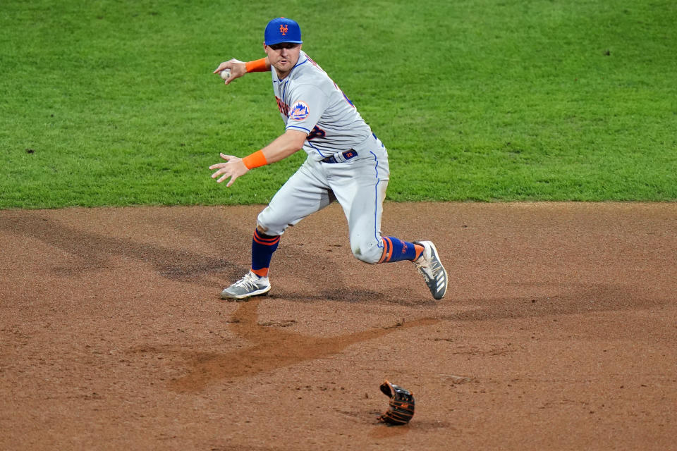 New York Mets third baseman J.D. Davis throws to first after losing his glove while fielding a single by Philadelphia Phillies' Alec Bohm during the fifth inning of a baseball game, Tuesday, Sept. 15, 2020, in Philadelphia. (AP Photo/Matt Slocum)