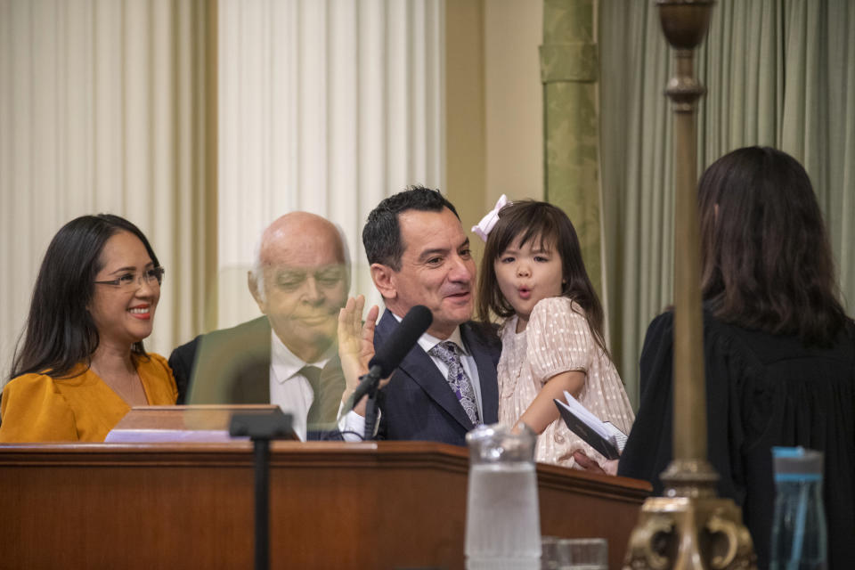 Assemblyman Anthony Rendon holds his daughter Vienna as he is accompanied by his wife Annie Lam and father Tom Rendon while he is sworn in as Speaker of the Assembly by California Supreme Court Justice Patricia Guerrero during the opening session of the California Legislature in Sacramento, Calif., Monday, Dec. 5, 2022. The legislature returned to work on Monday to swear in new members and elect leaders for the upcoming session. (AP Photo/José Luis Villegas Pool)