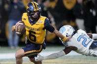 FILE - West Virginia quarterback Garrett Greene runs past North Carolina defensive back Kaleb Cost during the first half of an NCAA college football game at the Duke's Mayo Bowl Wednesday, Dec. 27, 2023, in Charlotte, N.C. As a junior Greene emerged as a solid dual threat in his first full season as a starter. (AP Photo/Chris Carlson, File)