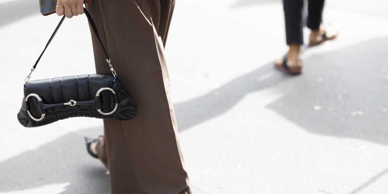 a person carrying a gucci horsebit handbag