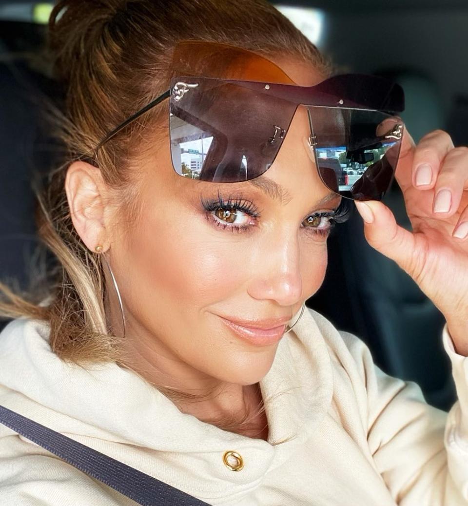 JLo in the car pulling up her sunglasses