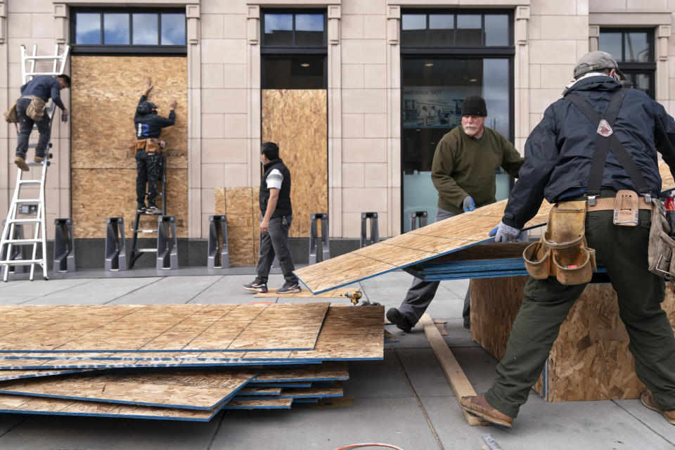 Ahead of the presidential election, workers with Baguer Construction LLC board up a Walgreens on U Street NW, Friday, Oct. 30, 2020, in Washington. The site manager said they had been hired to put protective coverings on several Walgreens throughout the city. (AP Photo/Jacquelyn Martin)