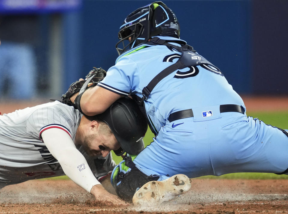 Minnesota Twins' Ryan Jeffers scores on a sacrifice fly by Michael A. Taylor ahead of the tag by Blue Jays catcher Alejandro Kirk during the 10th inning of a baseball game Friday, June 9, 2023, in Toronto. (Mark Blinch/The Canadian Press via AP