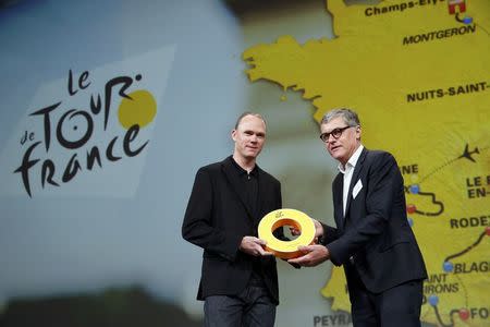 ASO's Laurent Lachaux (R), Commercial and Marketing Director at Amaury Sport Organisation, presents rider Chris Froome of Britain with a gift after the presentation of the itinerary of the 2017 Tour de France cycling race during a news conference in Paris, France, October 18, 2016. REUTERS/Benoit Tessier