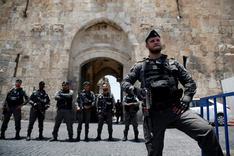 Israeli security forces stand guard as Palestinians worshippers demonstrate outside the Lions Gate, a main entrance to the Al-Aqsa mosque compound, due to new security measures by Israeli authorities, in Jerusalem's Old City on July 17, 2017