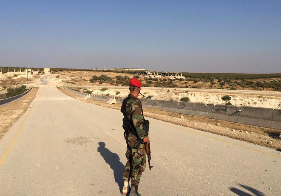 FILE - This Aug. 24, 2019, file photo, a Syrian soldier in the northwestern town of Khan Sheikoun, stands on the highway that links the capital Damascus with the northern city of Aleppo, Syria. The M5 highway, recaptured by President Bashar Assad’s forces this week, is arguably the most coveted prize in Syria’s civil war. The strategic highway is vital for Syria’s economy as well as for moving troops. (AP Photo/Albert Aji, File)