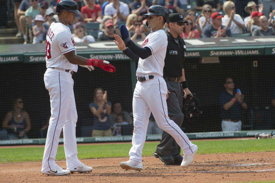 Cleveland Guardians' Oscar Gonzalez, left, greets Andres Gimenez after they scored on a two-run single by Owen Miller during the fourth inning in the first game of a baseball doubleheader against the Minnesota Twins, Saturday, Sept. 17, 2022, in Cleveland. (AP Photo/Phil Long)