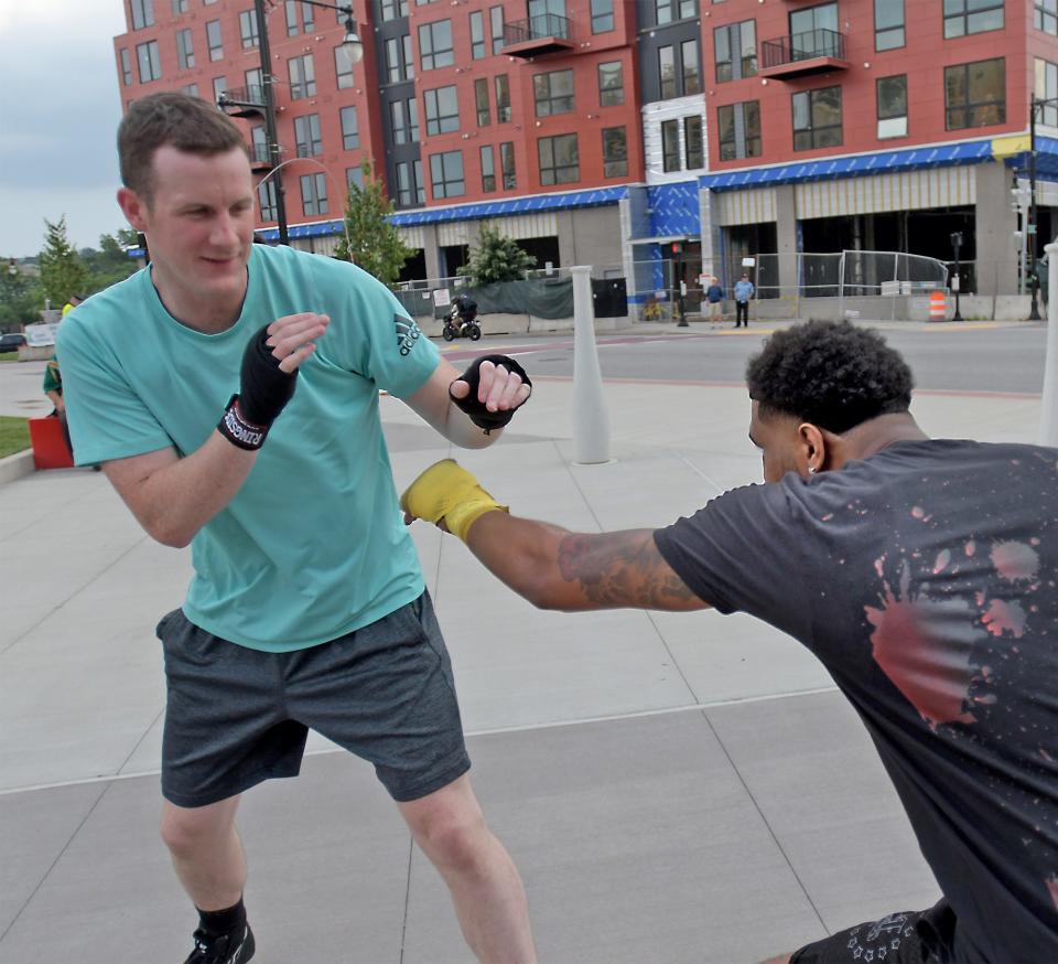 Worcester Police Officer Neal Sullivan, left, works out in front of Polar Park with Worcester's Kendrick Ball Jr. to promote the Aug. 4 boxing card at the event.