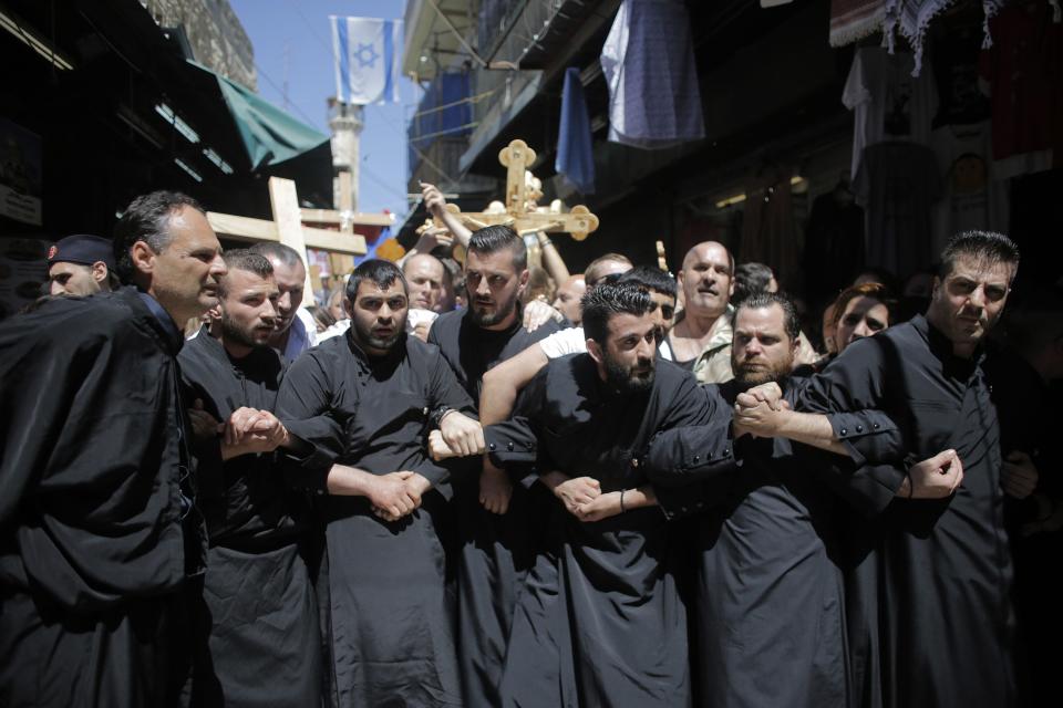 Christian worshippers lock arms during a procession along the Via Dolorosa on Good Friday in Jerusalem's Old City