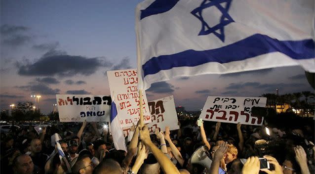 Protesters hold signs and shout slogans against the wedding of groom Mahmoud Mansour, 26, and bride Maral Malka, 23, outside a wedding hall in Rishon Lezion, near Tel Aviv. Photo: Reuters.