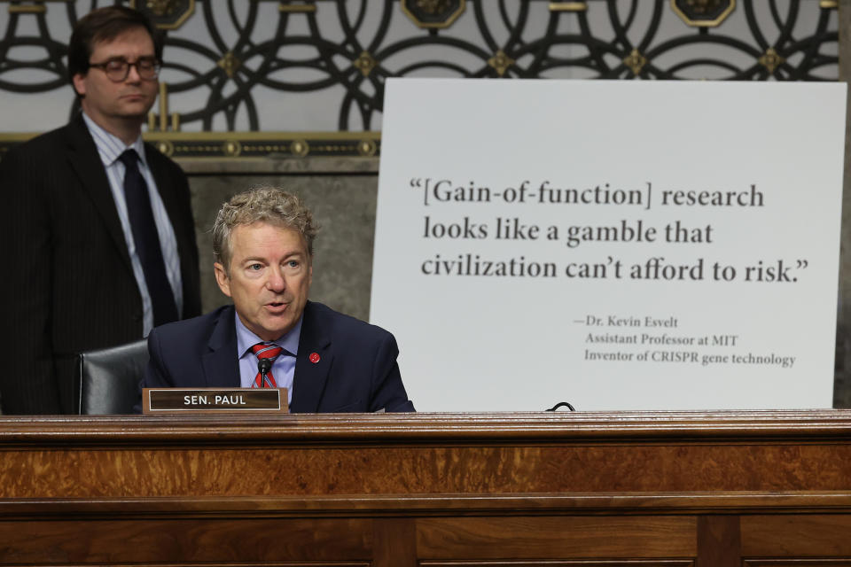 Sen. Rand Paul sits in front of a sign reading, 