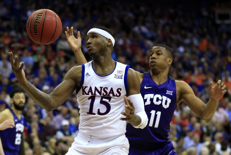 Kansas forward Carlton Bragg Jr., (15) rebounds against TCU guard Brandon Parrish (11) during first half of an NCAA college basketball game in the quarterfinal round of the Big 12 tournament in Kansas City, Mo., Thursday, March 9, 2017. (AP Photo/Orlin Wagner)