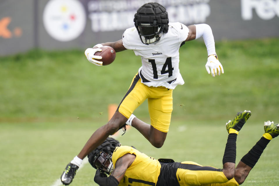 Pittsburgh Steelers wide receiver George Pickens (14) leaps over defensive back Justin Layne during a training camp drill. (AP Photo/Keith Srakocic)
