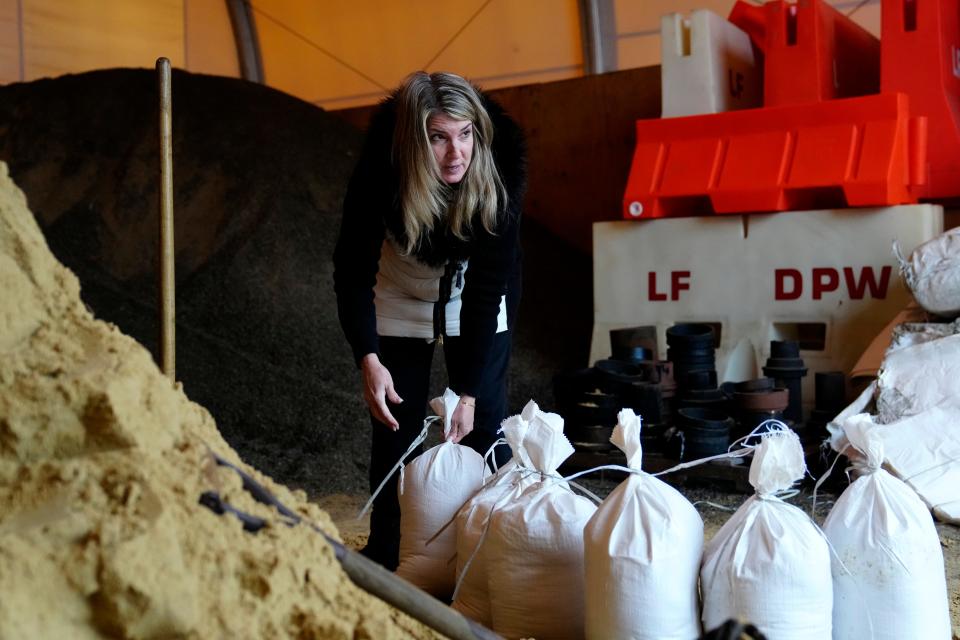 Cindy Miseta pauses filling a sand bags as she looks outside at the Little Falls DPW, where it already started raining, Tuesday afternoon, January 9, 2024. Floods are expected in parts of northern New Jersey Wednesday. Miseta, a real estate agent for Realty Executives, was there filling bags for a home she is selling.