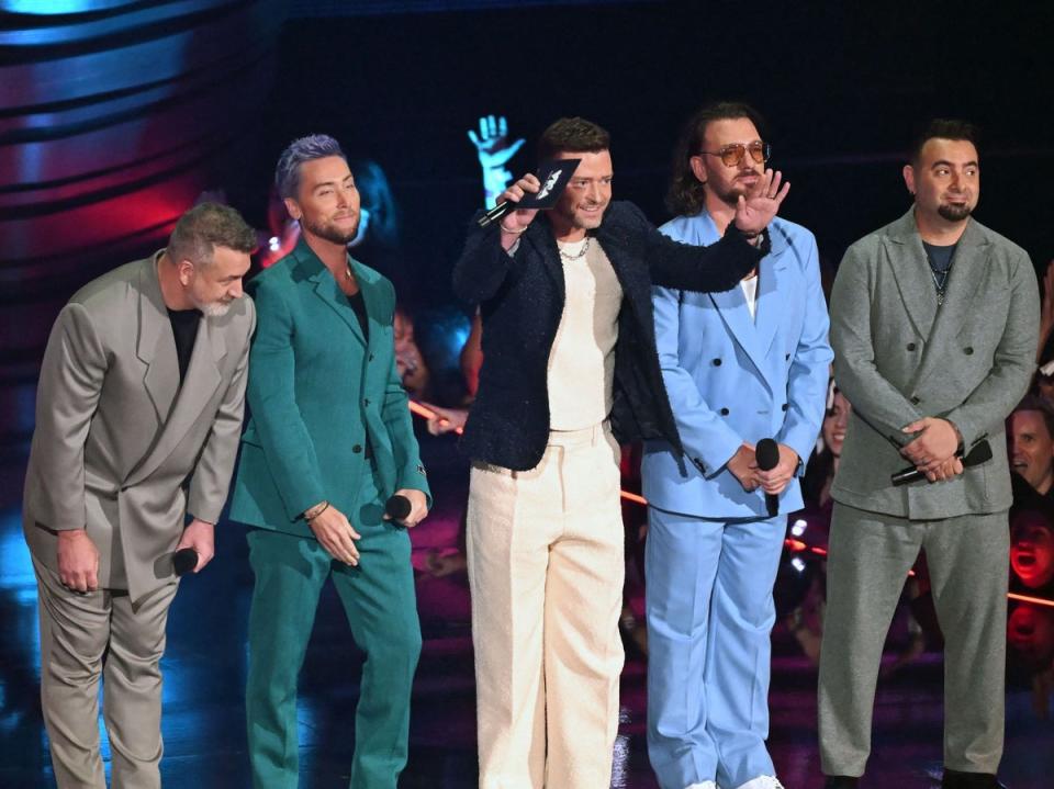 (From left) Joey Fatone, Lance Bass, Justin Timberlake, JC Chasez and Chris Kirkpatrick of former boy band NSYNC speak onstage during the MTV Video Music Awards (AFP via Getty Images)