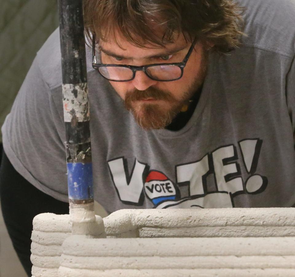 Brian Marshall concentrates on the pressure level output as he helps guide the 3D printing of concrete at MADCO3D Friday, Dec. 8, 2023 in Rochester.