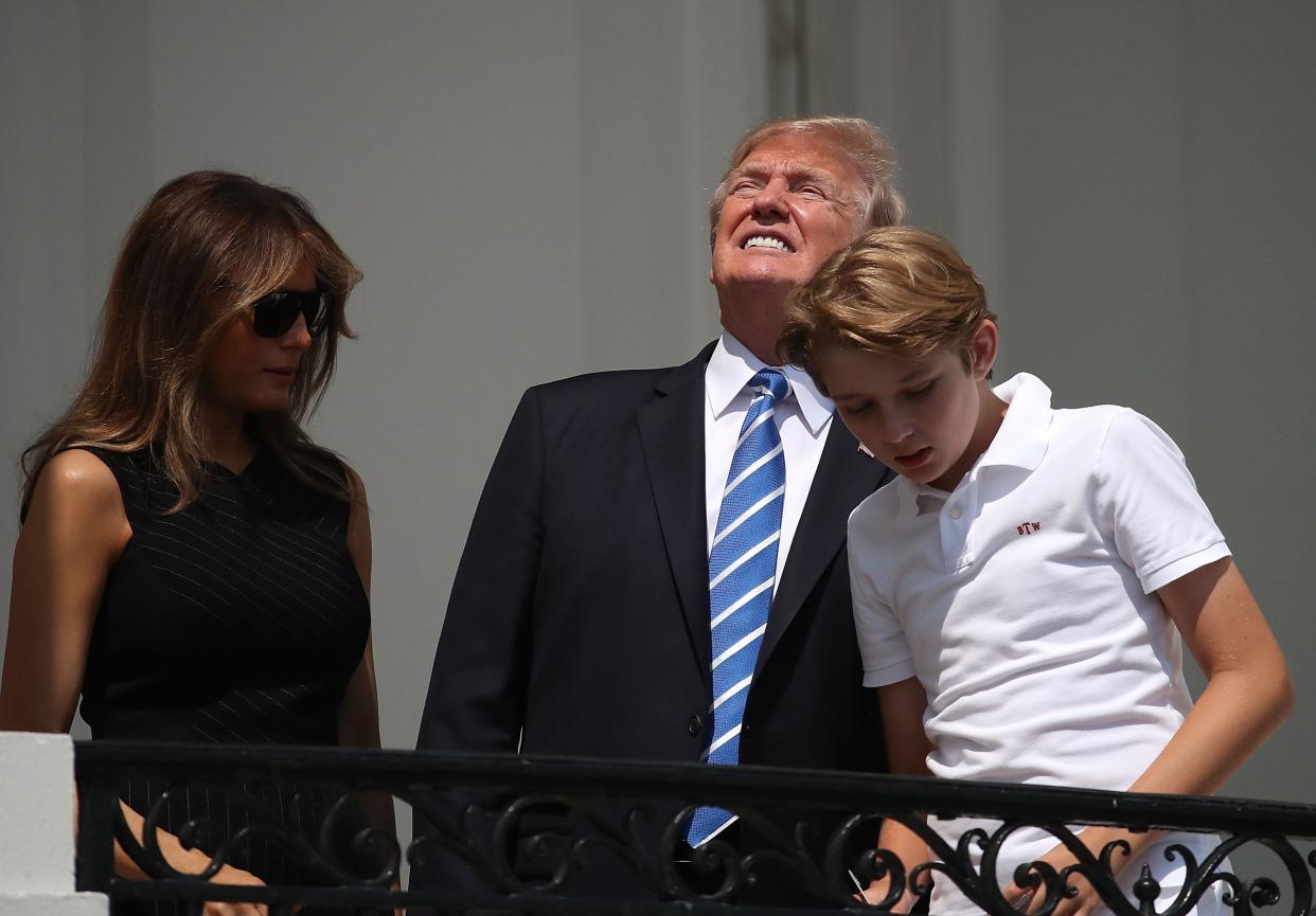 President Trump looks up toward the Solar Eclipse while standing with his wife first lady Melania Trump and their son Barron, on the Truman Balcony at the White House on August 21, 2017 in Washington, D.C.