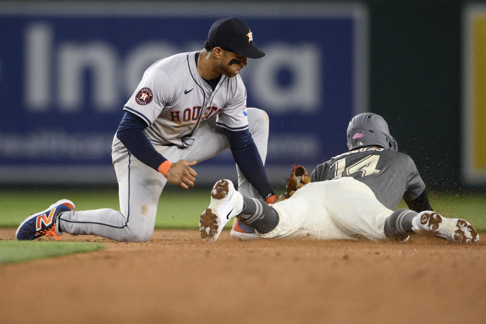 Houston Astros shortstop Jeremy Pena, left, tags out Washington Nationals' Ildemaro Vargas, right, who was attempting to steal second base during the eighth inning of a baseball game, Friday, April 19, 2024, in Washington. The Nationals challenged the play but it was upheld on review. (AP Photo/Nick Wass)