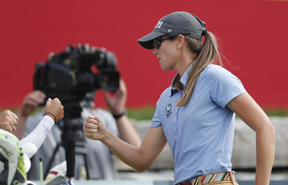 Cydney Clanton receives a fist bump after her shot from the 18th tee during the third round of the LPGA's Dow Great Lakes Bay Invitational golf tournament Friday, July 19, 2019, in Midland, Mich. (AP Photo/Carlos Osorio)