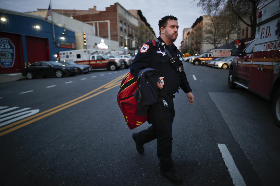 In this April 23, 2020, photo FDNY paramedic Alex Tull, who has recently recovered from COVID-19, prepares to begin his shift outside EMS station 26, the "Tinhouse", in the Bronx borough of New York. (AP Photo/John Minchillo)