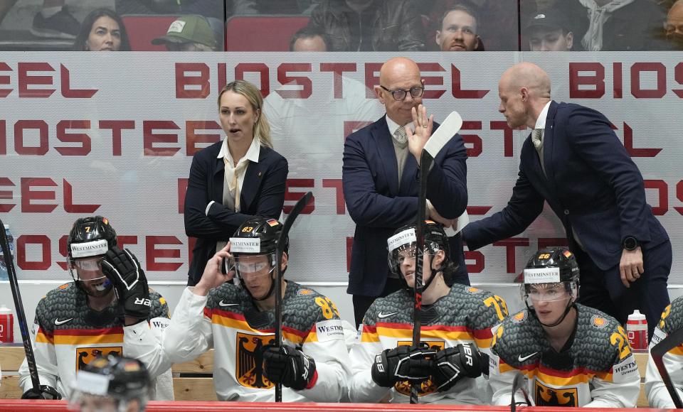 FILE - Germany's assistant coaches Jessica Campbell, Tom Rowe and head coach Toni Soderholm, from left, react on the bench during the Hockey World Championship quarterfinal match between Germany and the Czech Republic in Helsinki, Finland, Thursday May 26, 2022. The Coachella Valley Firebirds have hired Jessica Campbell as the American Hockey League’s first female assistant coach. (AP Photo/Martin Meissner, File)