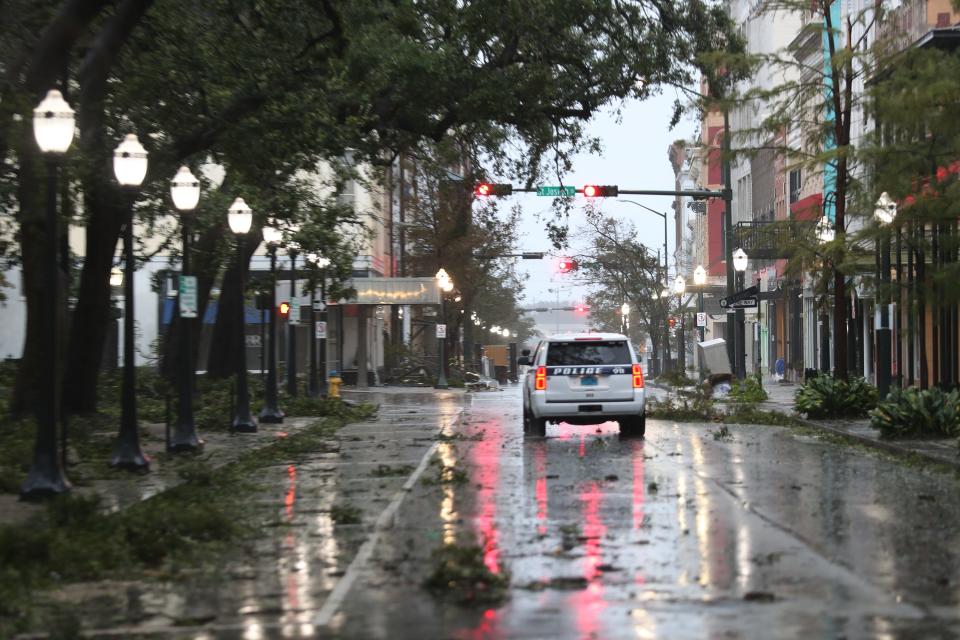 A police vehicle drives through a street strewn with tree branches as the winds and rain from Hurricane Sally pass through the area on September 16, 2020 in Mobile, Alabama.