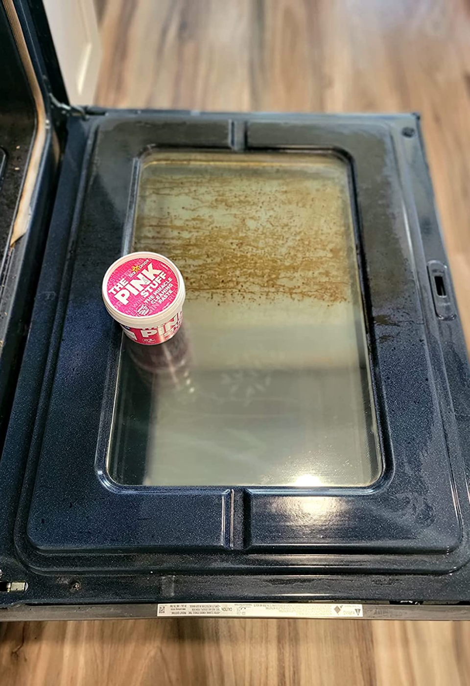 A reviewer's oven showing half of it clean where they used the Pink Stuff