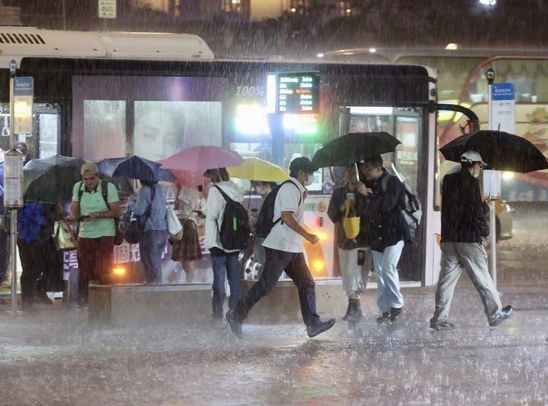 中央氣象署發布豪雨特報，31日北部地區有局部大雨發生的機率，注意雷擊及強陣風。圖為台北車站附近，沒帶雨具的民眾在雨中快步前行。（中央社）
