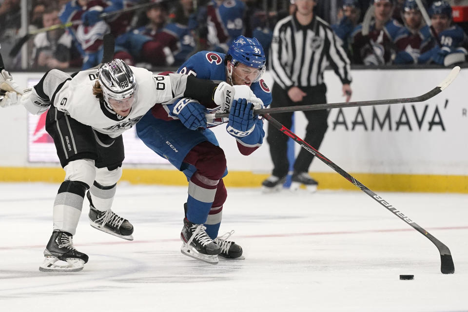 Los Angeles Kings right wing Samuel Fagemo, left, and Colorado Avalanche left wing Andre Burakovsky battle for the puck during the first period of an NHL hockey game Thursday, Jan. 20, 2022, in Los Angeles. (AP Photo/Mark J. Terrill)