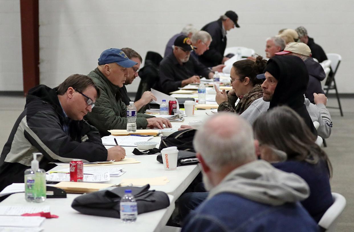 East Palestine residents fill out paperwork Friday to receive a $1,000 reimbursement from Norfolk Southern at Abundant Life Fellowship in New Waterford, Ohio.