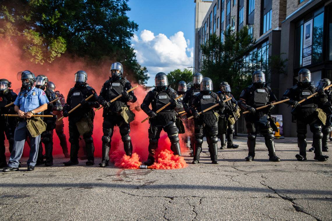 Police in riot gear deploy tear, gas pepper spray and smoke bombs against protesters near the intersection of McDowell and Davie Streets in downtown Raleigh Saturday, May 30, 2020.