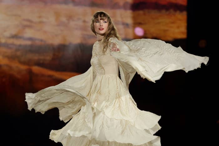 Taylor Swift dances and performs on stage in a flowing dress