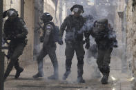 Palestinians shoot fireworks at Israeli police in the Old City of Jerusalem, Sunday, April 17, 2022. Israeli police clashed with Palestinians outside Al-Aqsa Mosque after police cleared Palestinians from the sprawling compound to facilitate the routine visit of Jews to the holy site and accused Palestinians of stockpiling stones in anticipation of violence. (AP Photo/Mahmoud Illean)