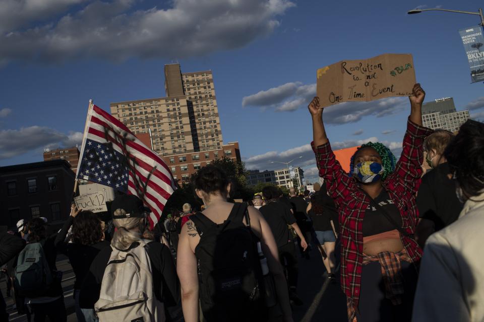 Protesters march down the street during a solidarity rally for George Floyd, Sunday, May 31, 2020, in the Brooklyn borough of New York. Protests were held throughout the city over the death of Floyd, a black man in police custody in Minneapolis who died after being restrained by police officers on Memorial Day. (AP Photo/Wong Maye-E)