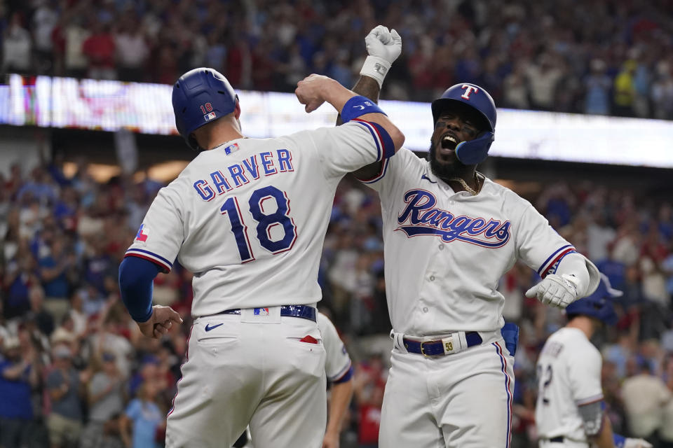 Texas Rangers' Adolis Garcia, right, celebrates his three-run home run with teammate Mitch Garver (18) in the third inning of Game 3 of a baseball AL Division Series against the Baltimore Orioles on Tuesday, Oct. 10, 2023, in Arlington, Texas. (AP Photo/Tony Gutierrez )