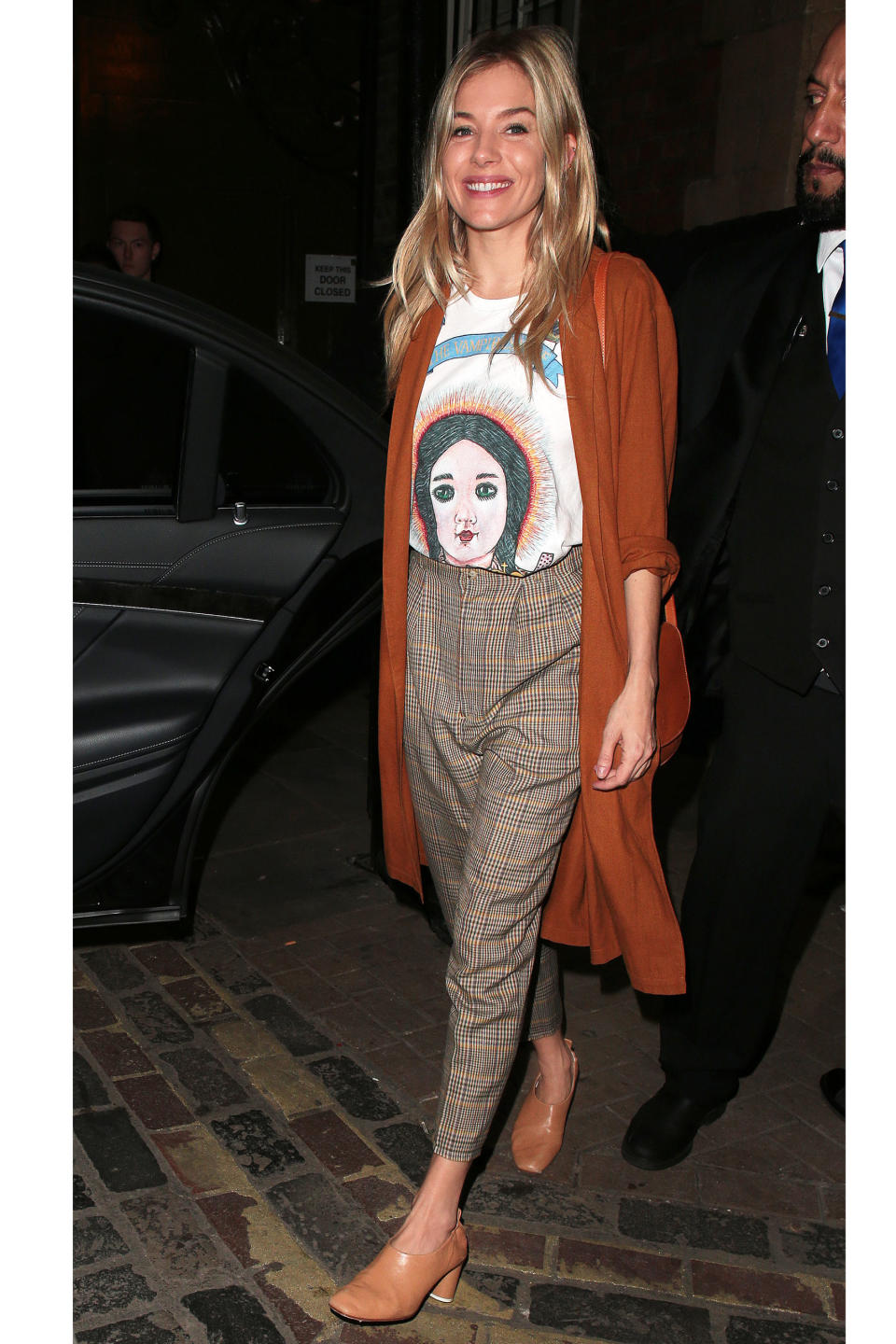 In The Vampire's Wife Graphic T-Shirt, A Long Cardigan Plaid Trousers And Gray Matters Shoes