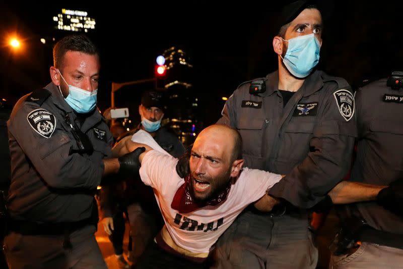 FILE PHOTO: Israelis protest against law that limits protests during coronavirus lockdown in Tel Aviv