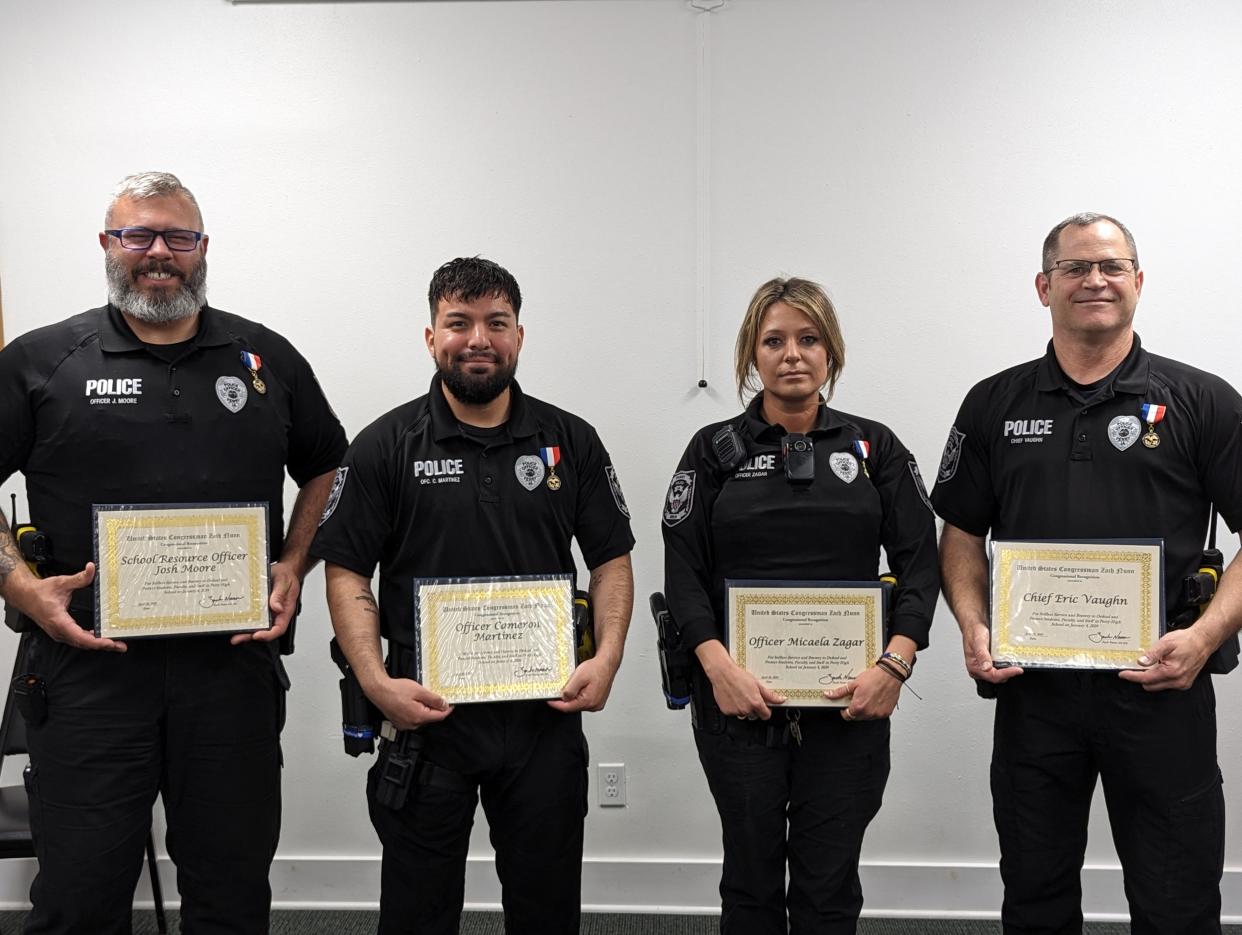 School Resource Officer Josh Moore, Officer Cameron Martinez, Officer Micaela Zagar and Chief Eric Vaughn pose for a photo after receiving the Iowa Medal of Merit during a ceremony on Friday, April 25, 2024, at the Perry Police Department.