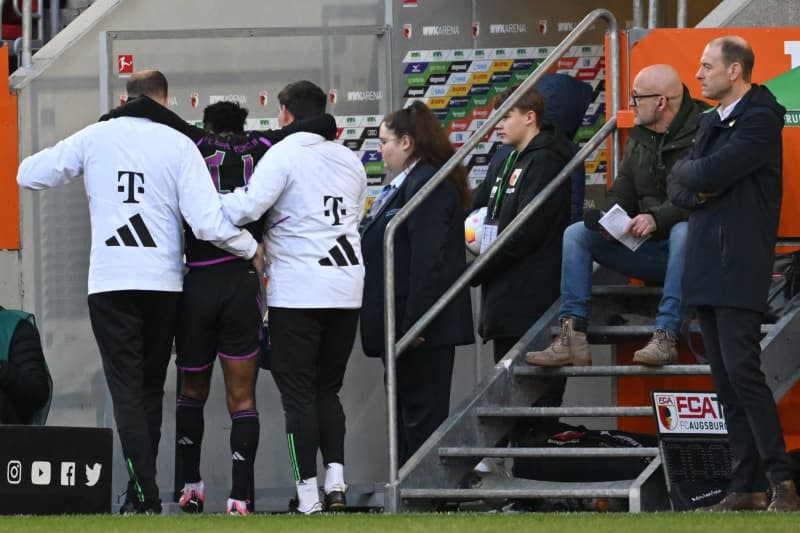 Bayern Munich's Kingsley Coman (2nd L) leaves the pitch after an injury during the German Bundesliga soccer match between FC Augsburg and Bayern Munich at the WWK-Arena. Sven Hoppe/dpa